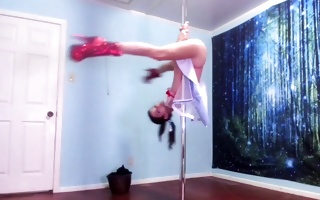 Nice-looking dark-haired in a cute clothes dances on a pole